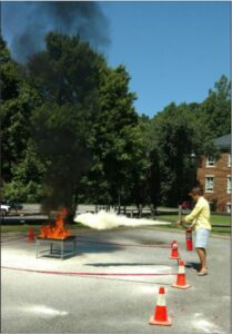 Eagle Fire technician putting out a small fire with a fire extinguisher