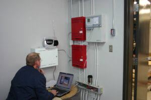 Employee-testing-our-fire-alarm-system-in-a-building